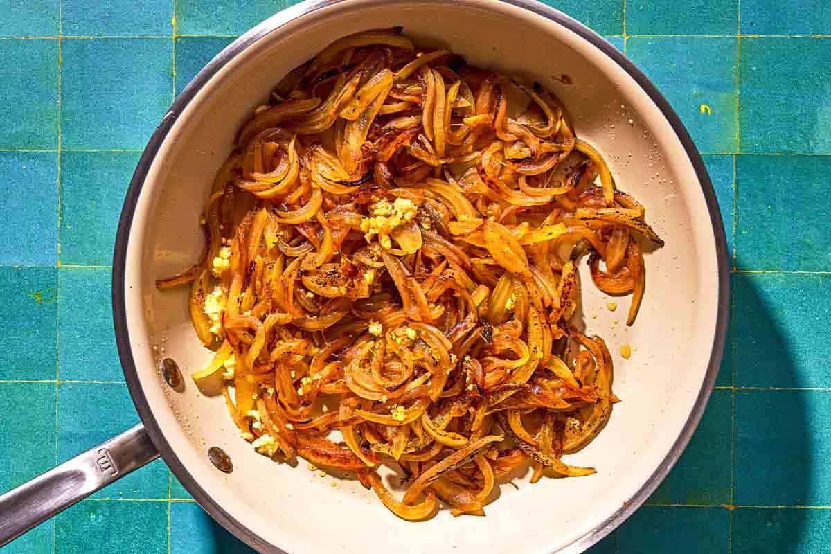 The fried onions for the beet soup in a skillet.