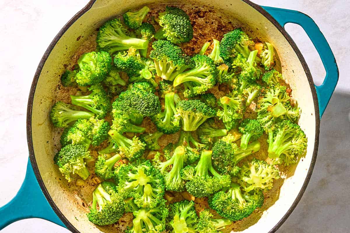 Broccoli cooking in a skillet.