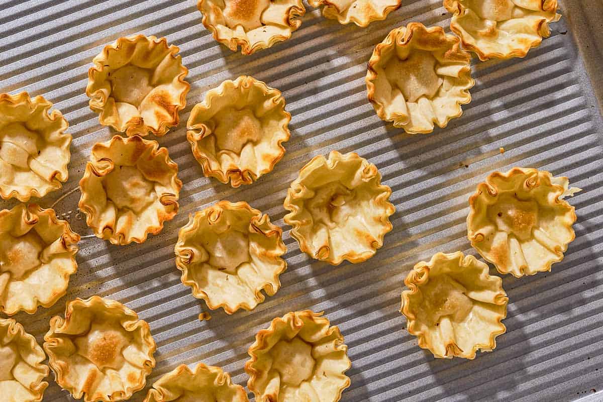 Baked phyllo cups on a sheet pan.