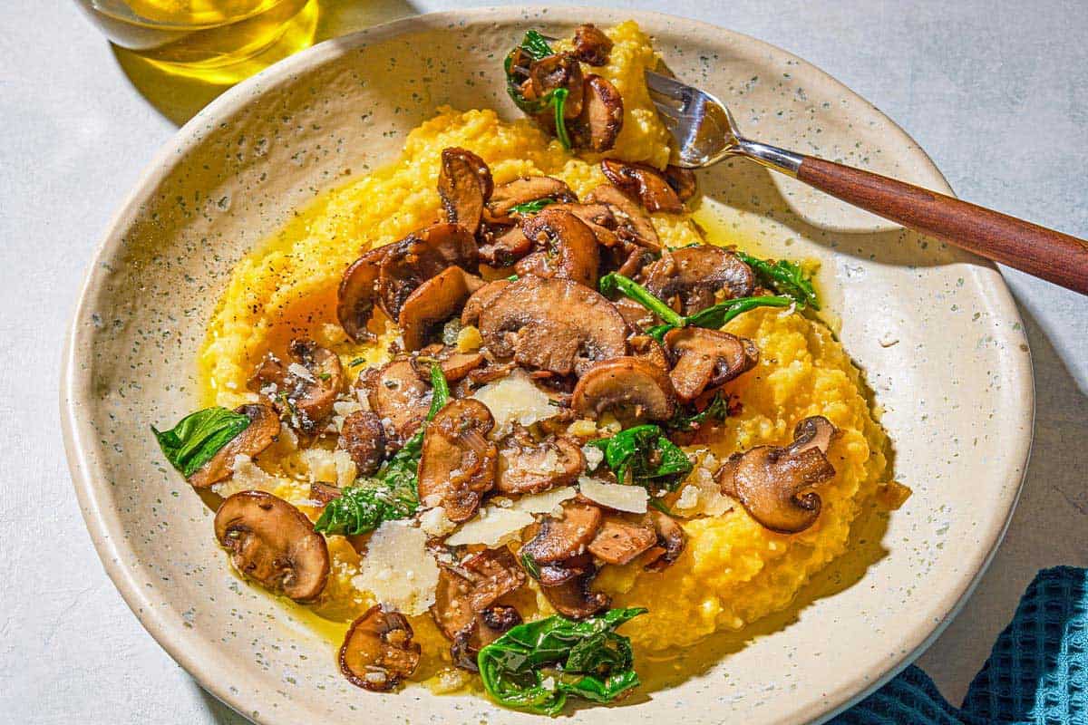 A plate of mushroom polenta with a fork.