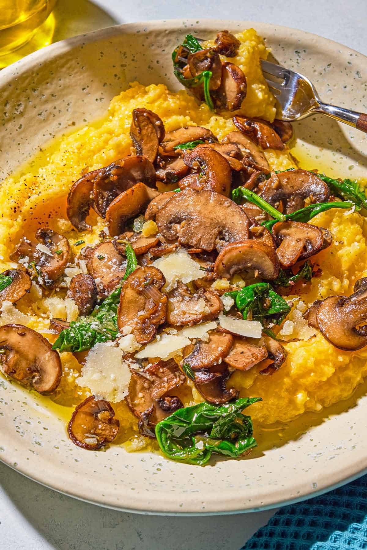 A plate of mushroom polenta with a fork.