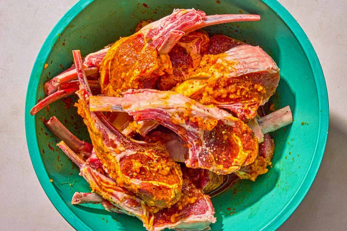 The lamb lollipops being marinated in a bow.