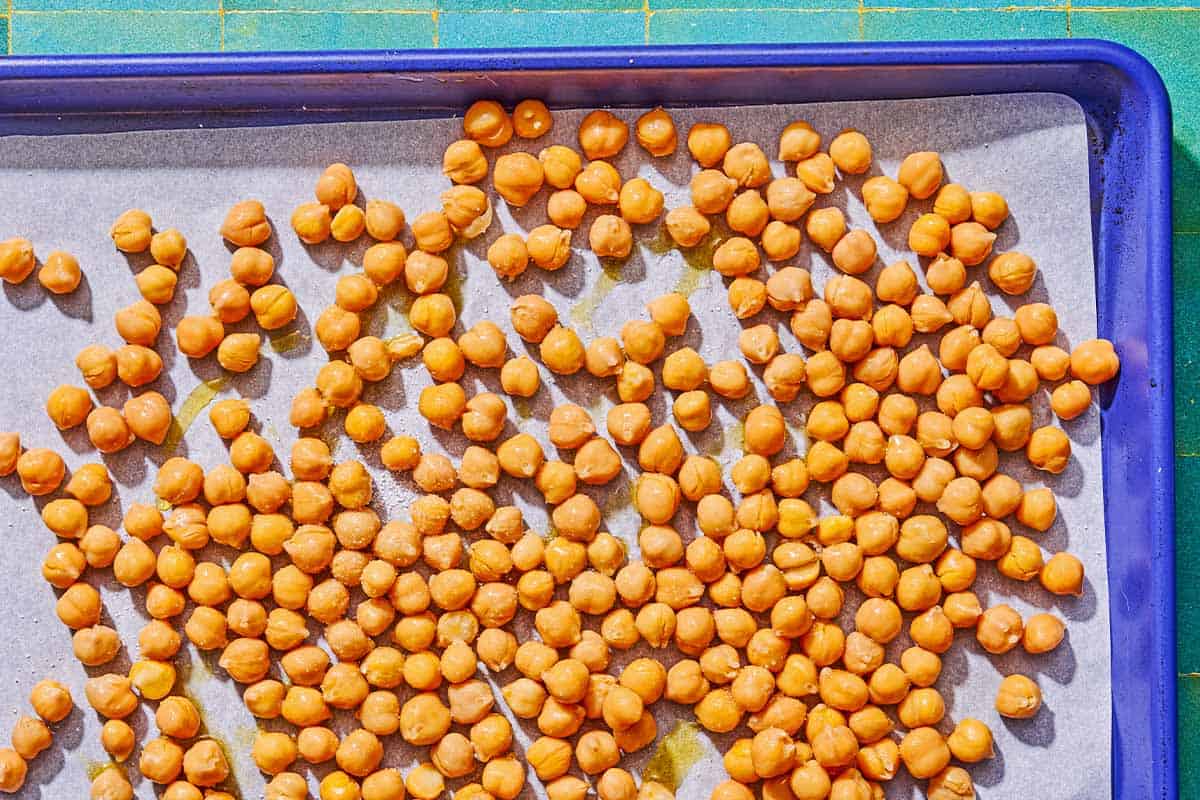 Chickpeas on a parchment lined sheet pan.