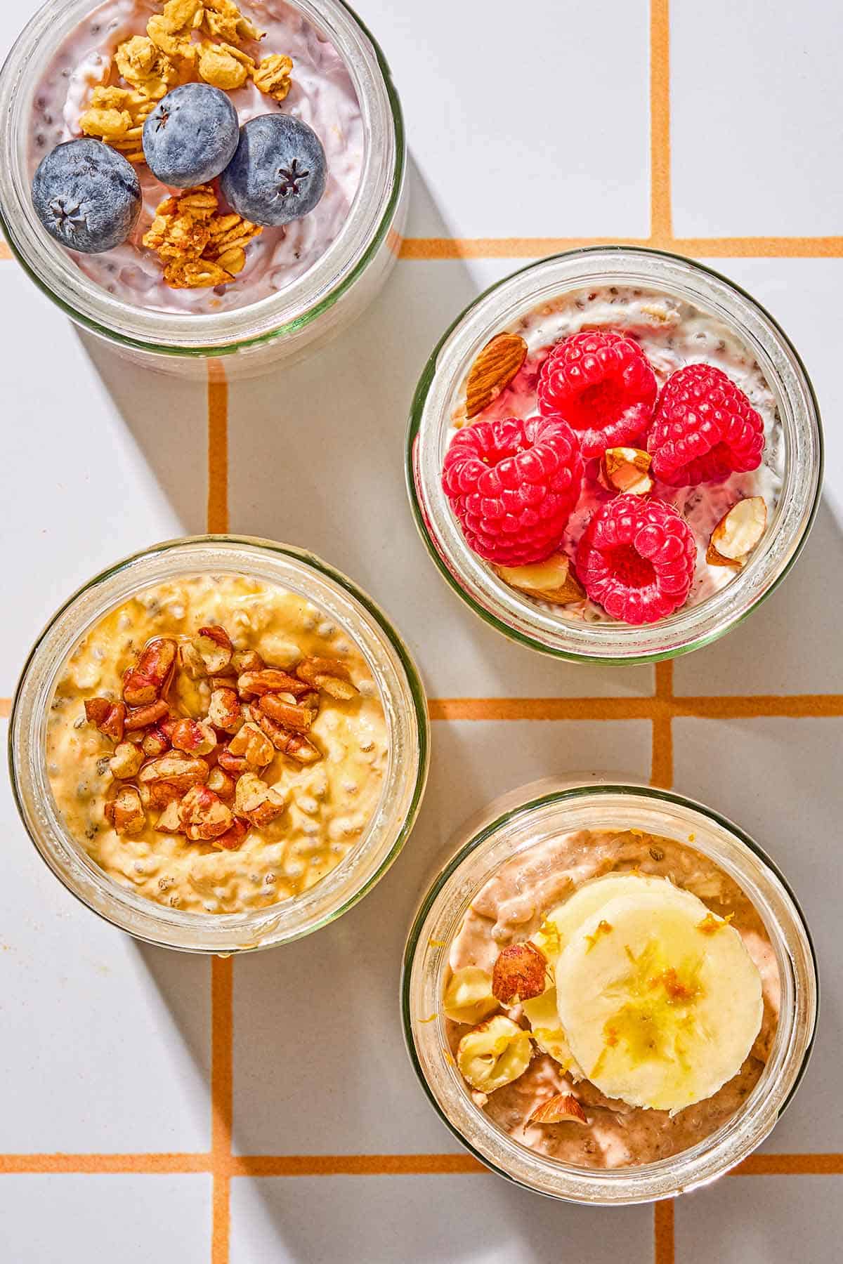Four jars of overnight oats with various toppings.