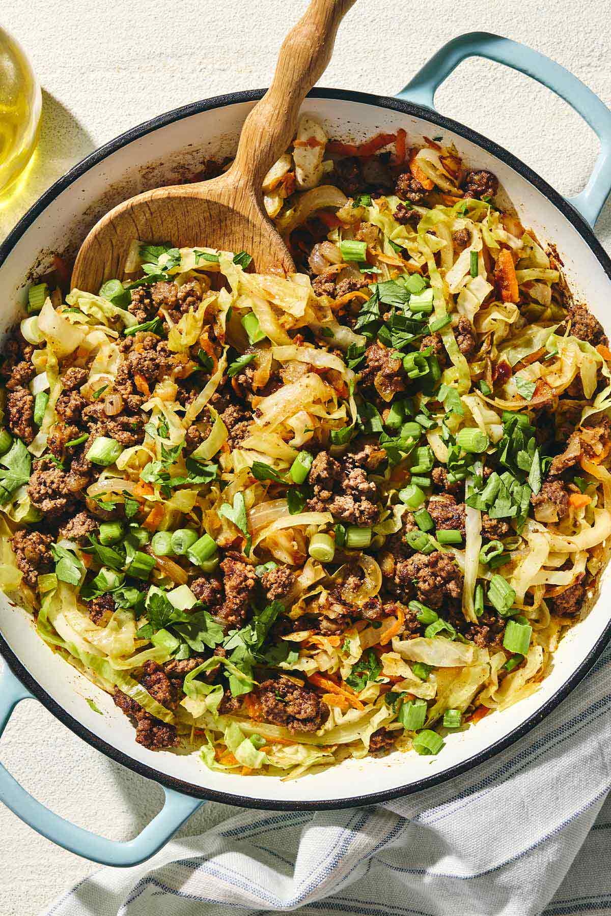 a skillet of Mediterranean beef and cabbage with spoon to stir