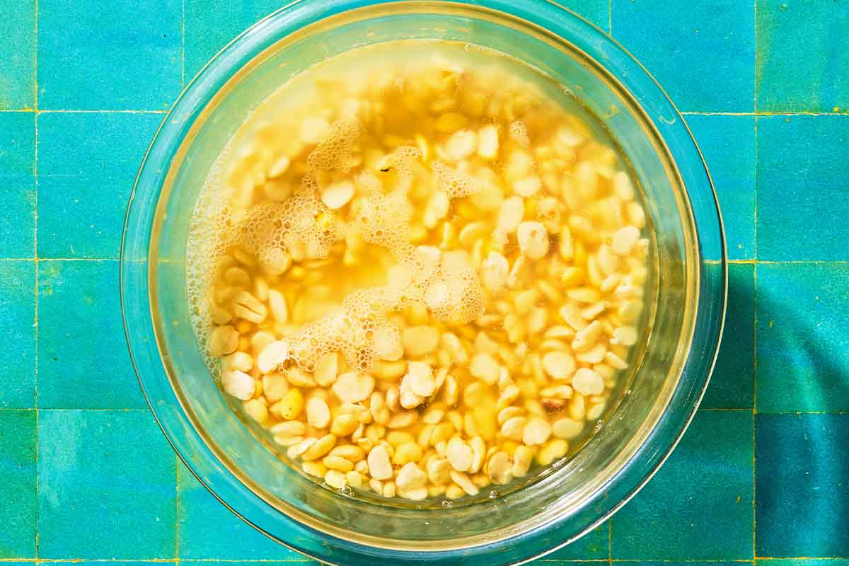 Split fava beans for the fava bean dip soaking in a bowl of water.