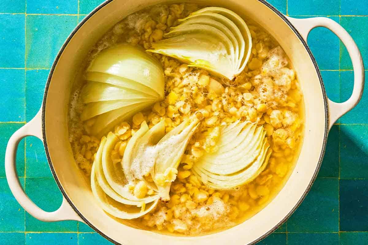The fava beans, onion and garlic for the fava bean dip simmering together in a pot.