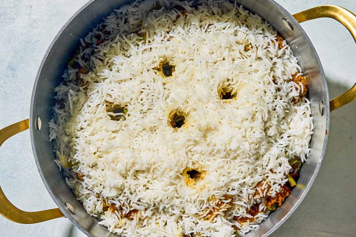 The layers of the loobia polo in a large pot.