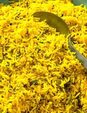 Turmeric rice in a serving bowl with a spoon.