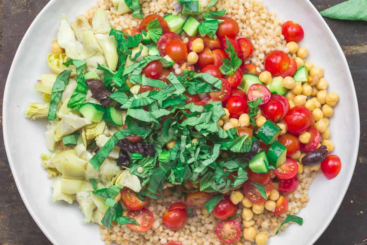 The ingredients for the couscous salad in a bowl just before being mixed together.