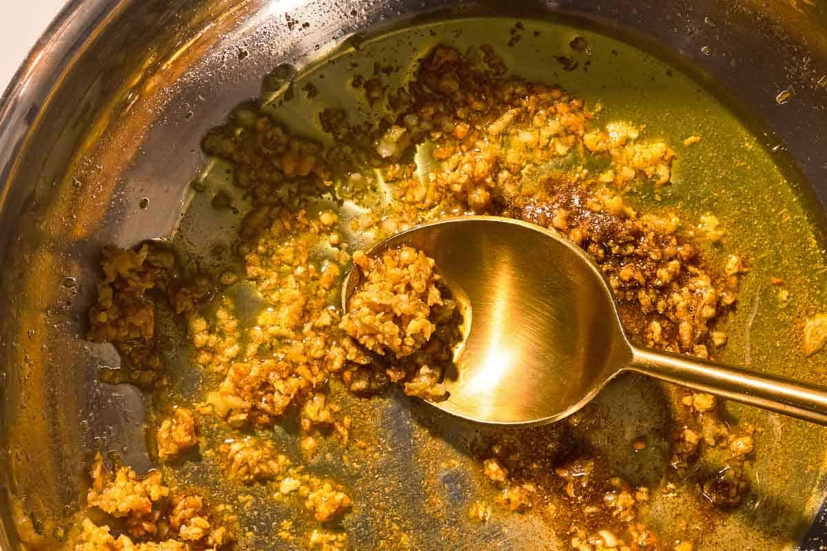 The tasha for the molokia recipe being stirred in a skillet with a spoon.