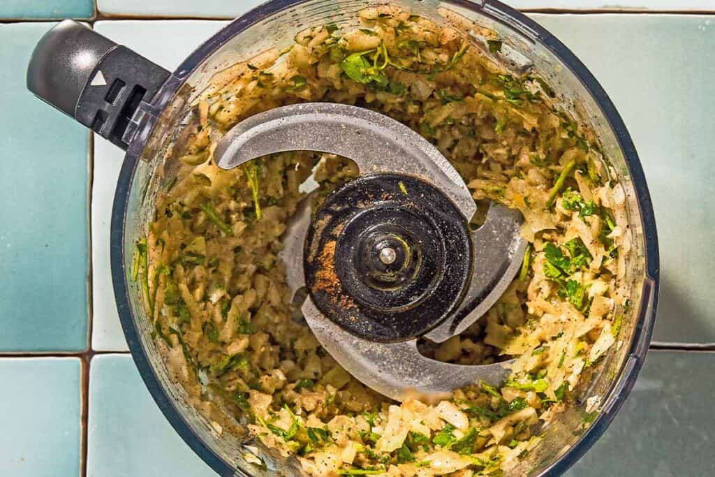 The garlic spice rub for the lamb kabobs in the bowl of a food processor fitted with a blade.