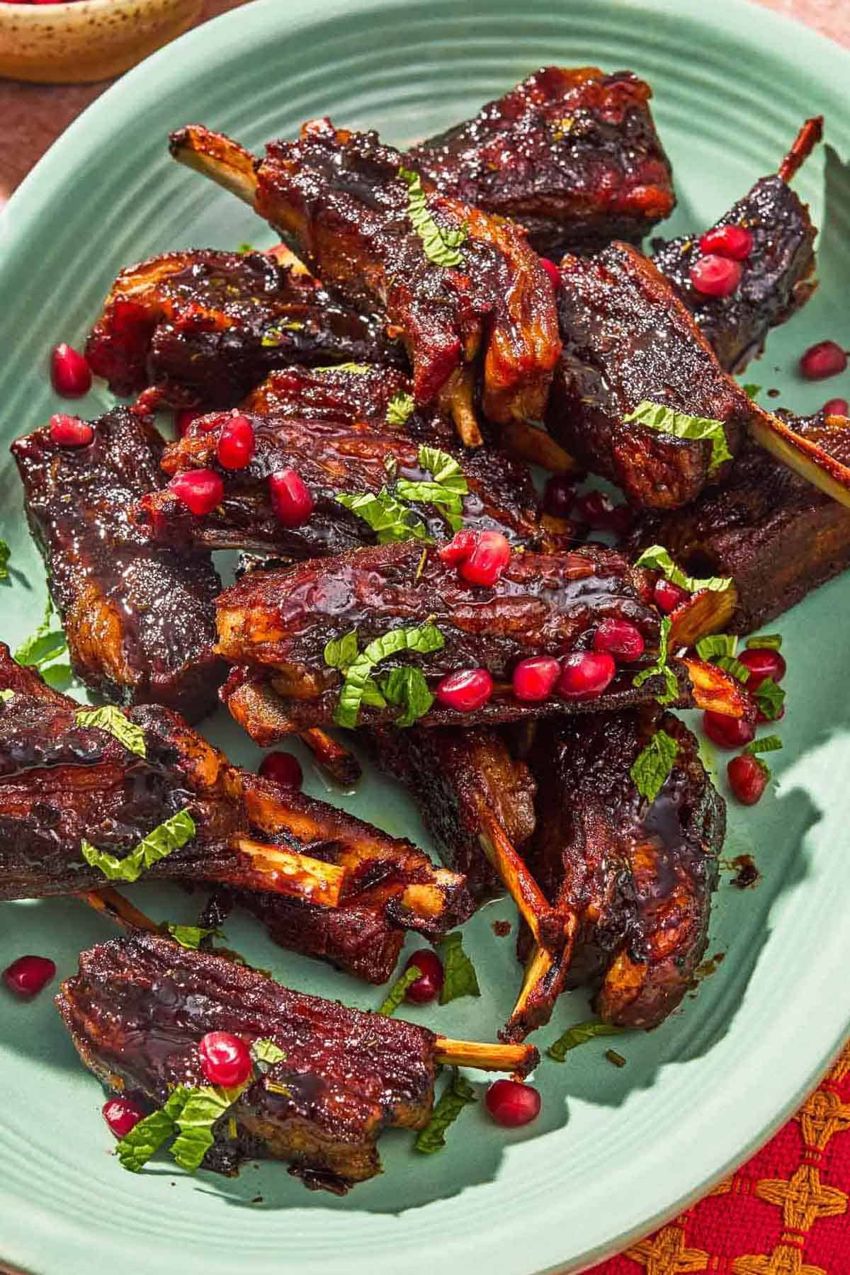 Platter of pomegranate glazed lamb ribs with fresh mint. 