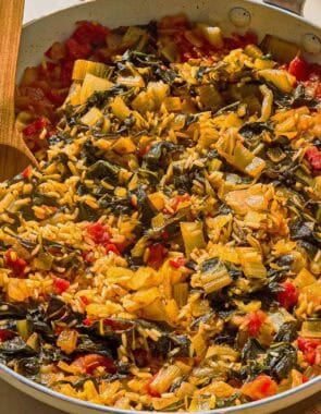 Swiss chard in a skillet with a wooden spoon.