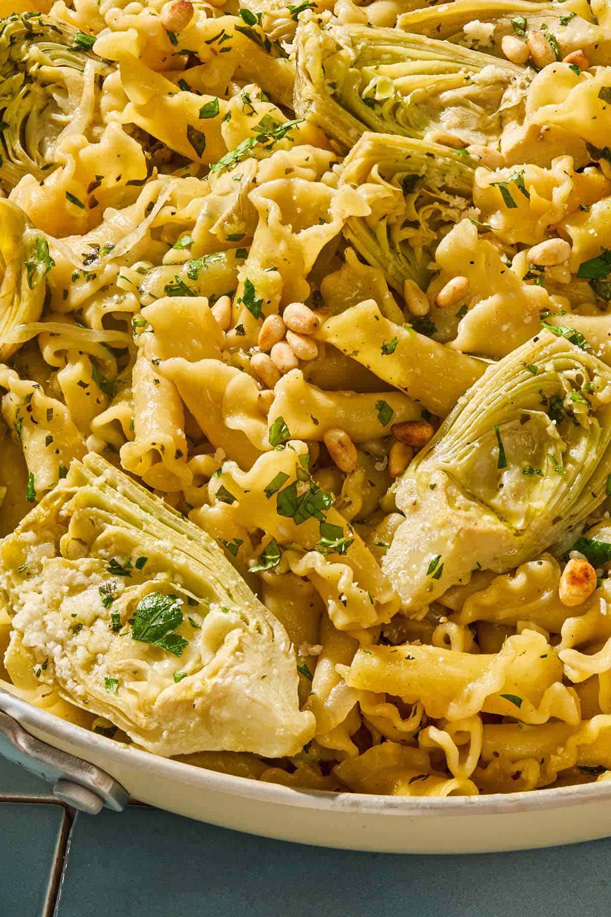 A close up of the artichoke pasta in a skillet.