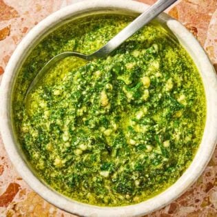 The basil pesto recipe in a bowl with a spoon.
