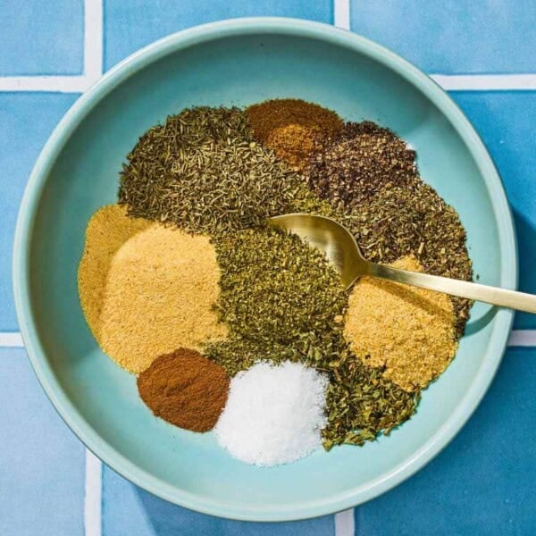 The individual seasonings for the Greek seasoning recipe in a bowl with a spoon just before being mixed together.