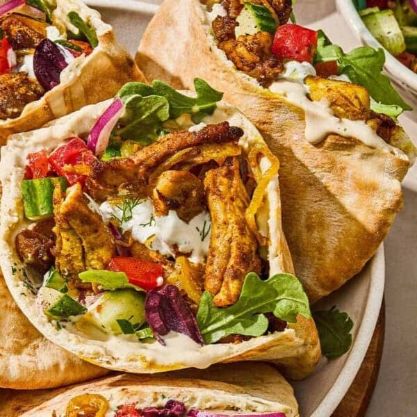 Several chicken shawarma pita sandwiches in a serving bowl for a weeknight dinner chicken recipe.