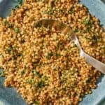 The pearl couscous recipe in a bowl with a spoon.