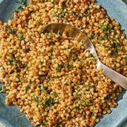 The pearl couscous recipe in a bowl with a spoon.