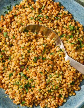 The pearl couscous recipe in a bowl with a spoon.