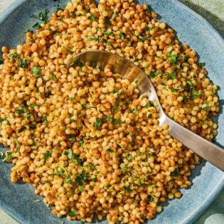 The pearl couscous recipe in a bowl with a spoon.