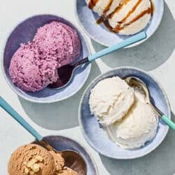 Bowls of tahini, blueberry, vanilla and chocolate hazelnut dairy free ice cream with spoons.