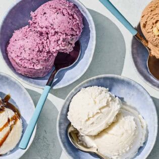 Bowls of tahini, blueberry, vanilla and chocolate hazelnut dairy free ice cream with spoons.