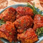 Honey mustard chicken on a platter with fresh herbs.