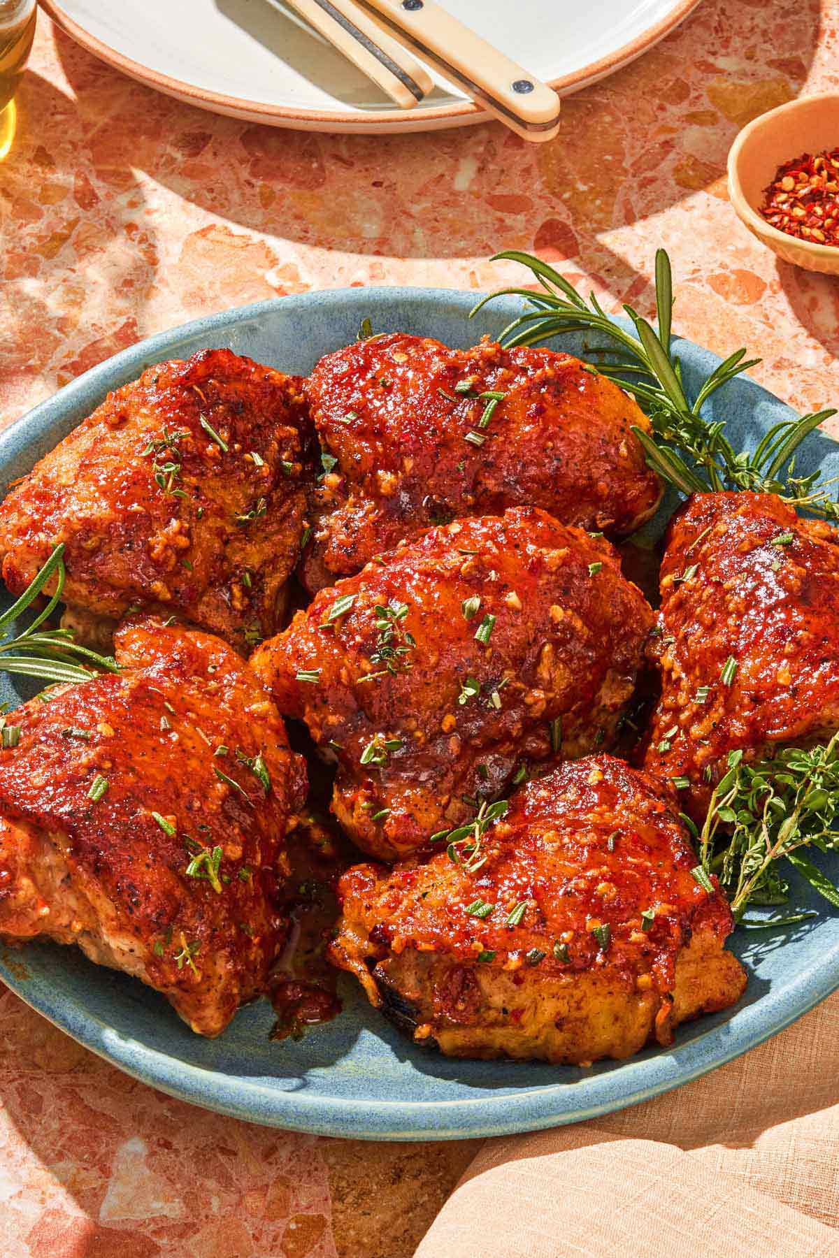 Honey mustard chicken on a platter with fresh herbs.