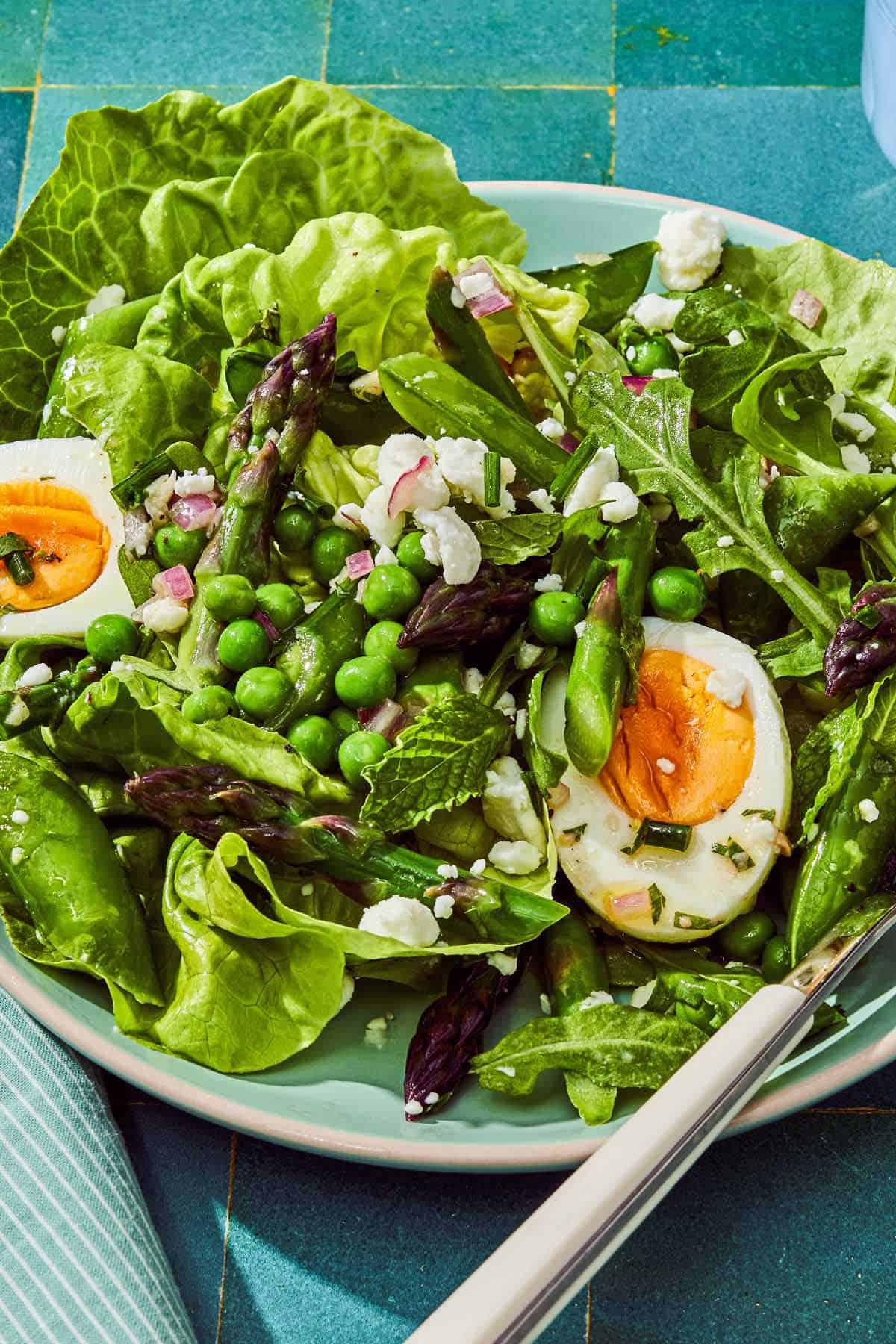 A serving of the spring green salad on a plate with a fork.