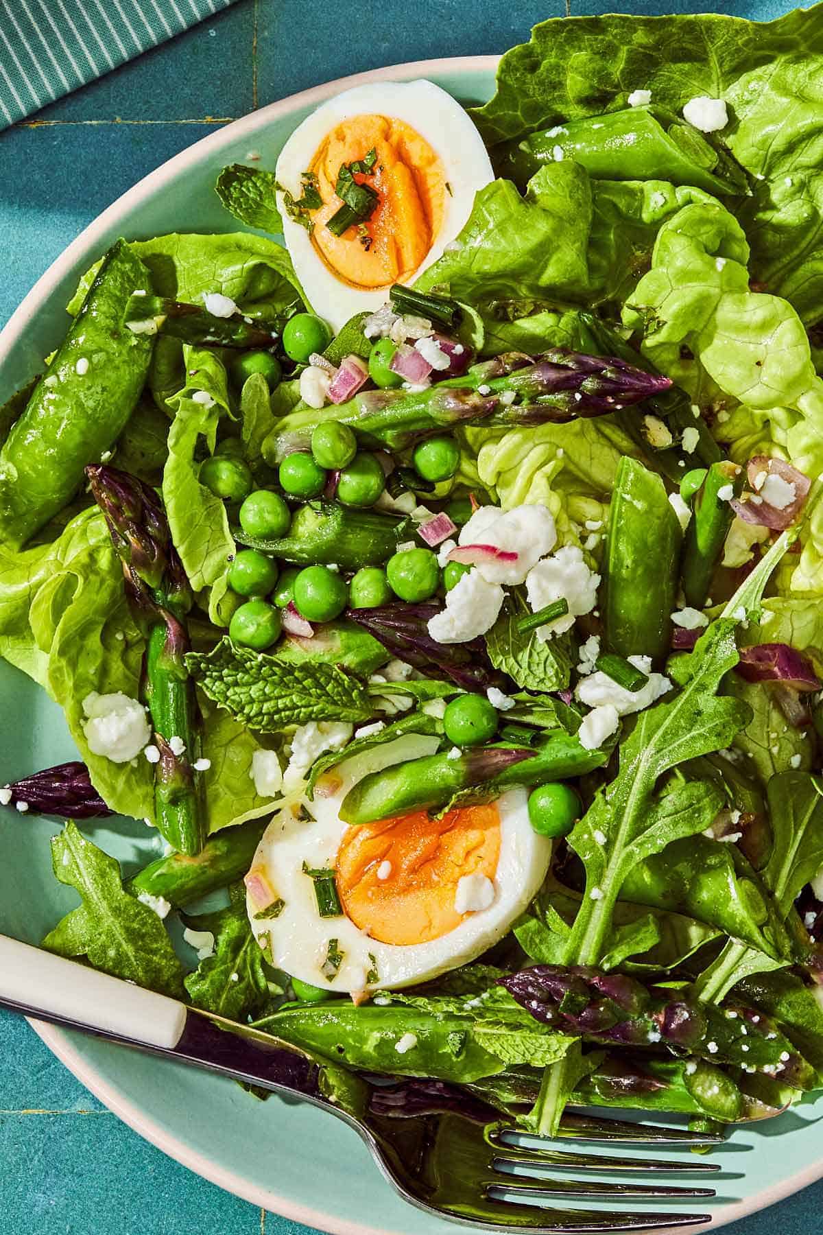 A serving of the spring green salad on a plate with a fork.