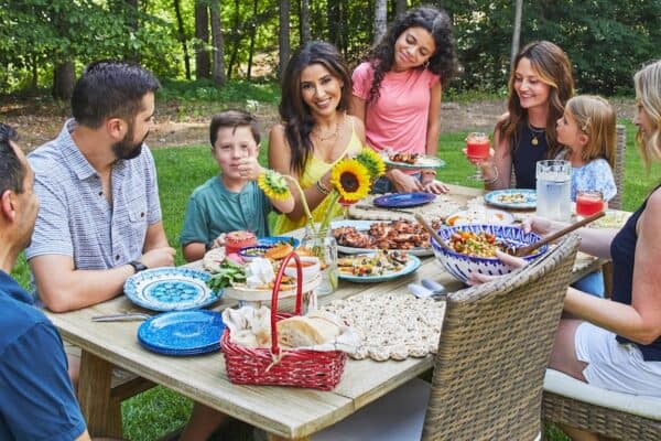 A family sat around an outdoor table with food.