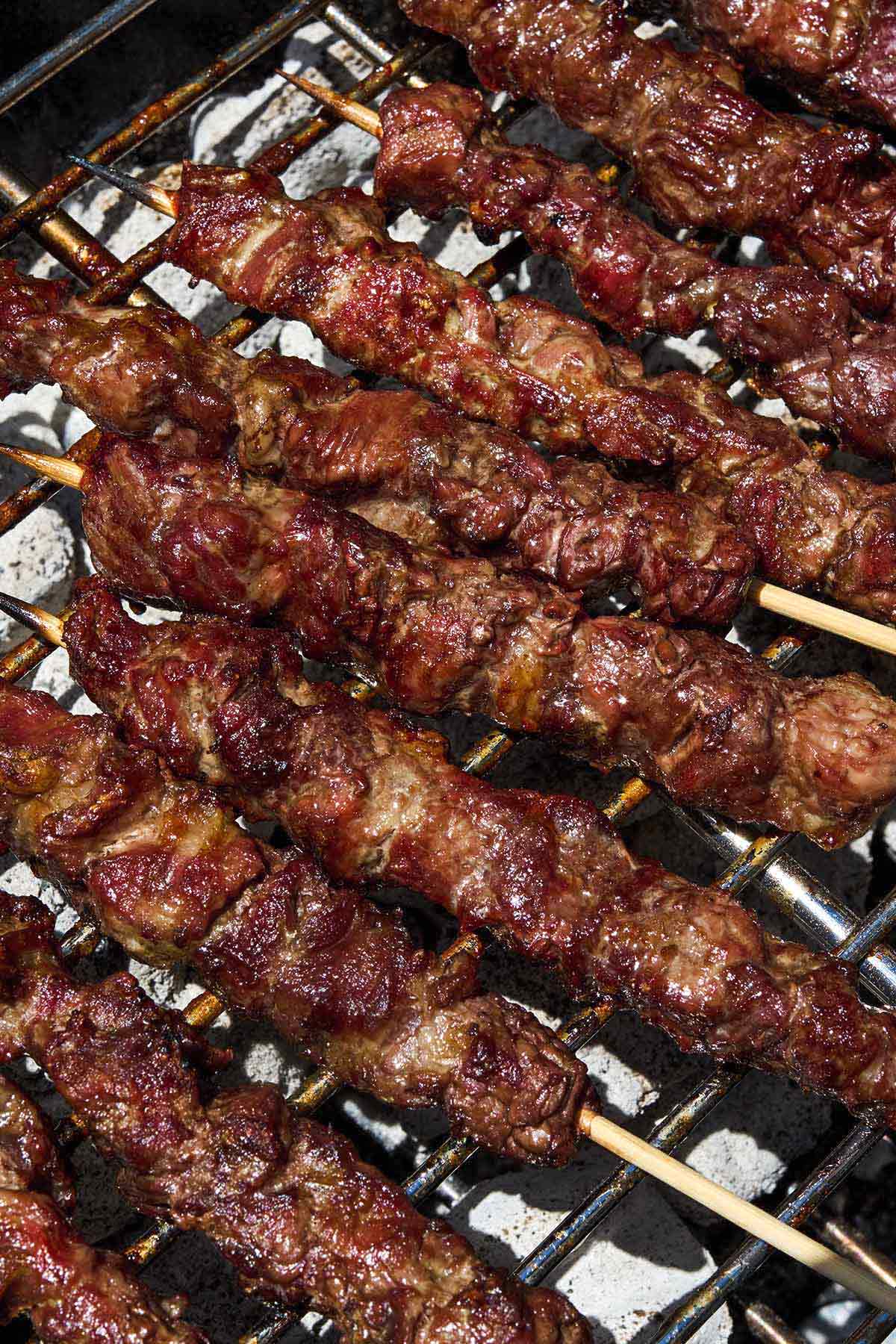 Several arrosticini skewers on a grill.