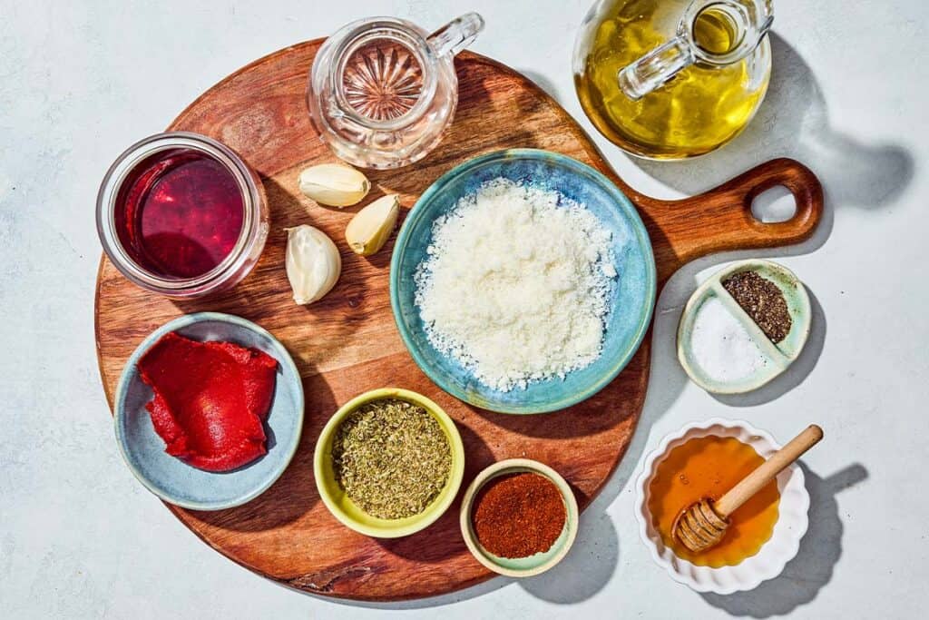 Ingredients for the italian salad dressing including olive oil, italian seasoning, red wine vinegar, distilled vinegar, Pecorino romano cheese, garlic, honey, tomato paste, sweet paprika, salt and pepper.