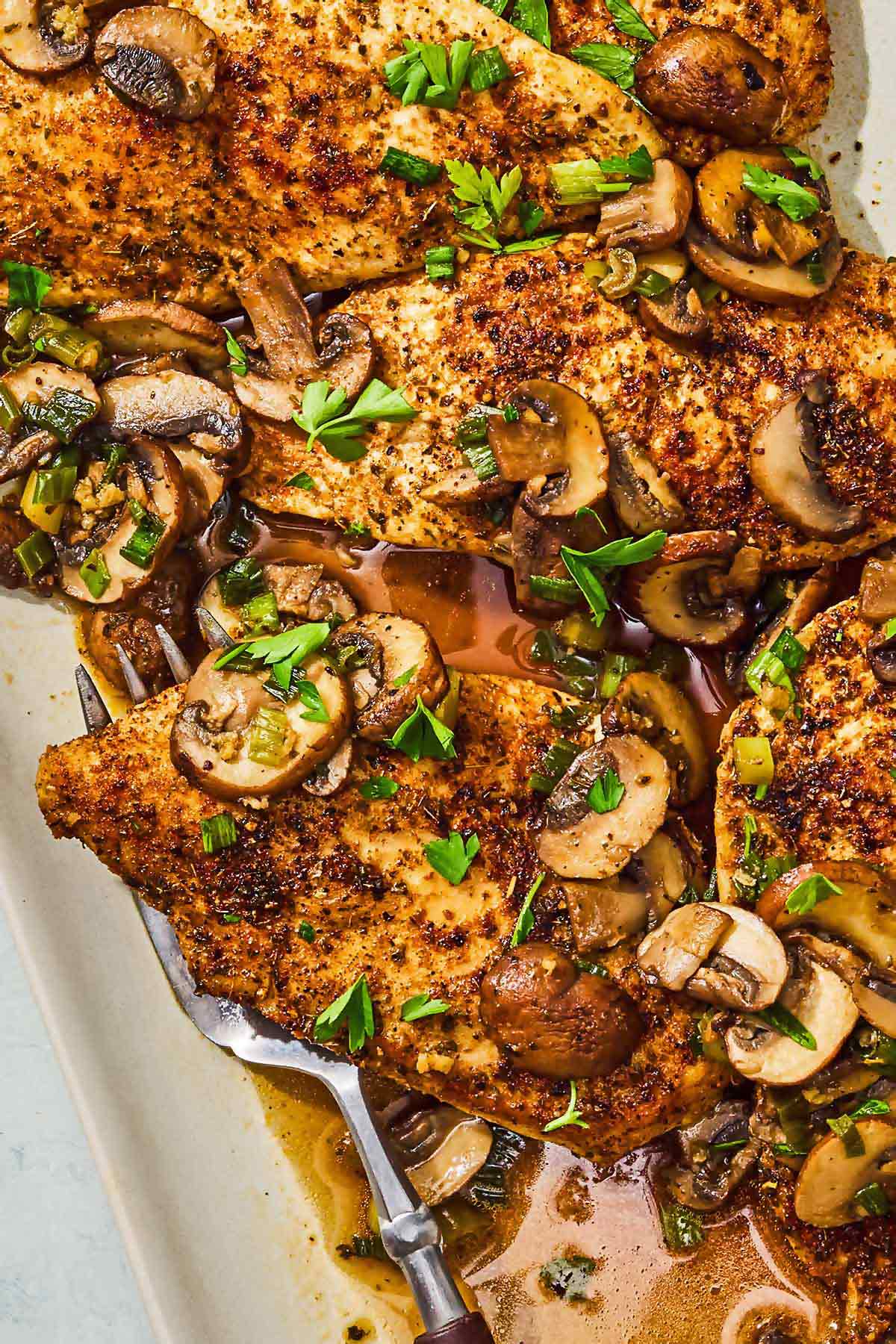 The chicken and mushroom recipe on a platter with a serving fork.
