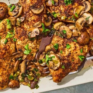 The chicken and mushroom recipe on a platter with a serving fork.