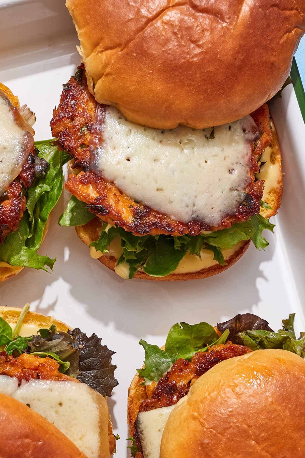 Four tuna burgers on a platter.