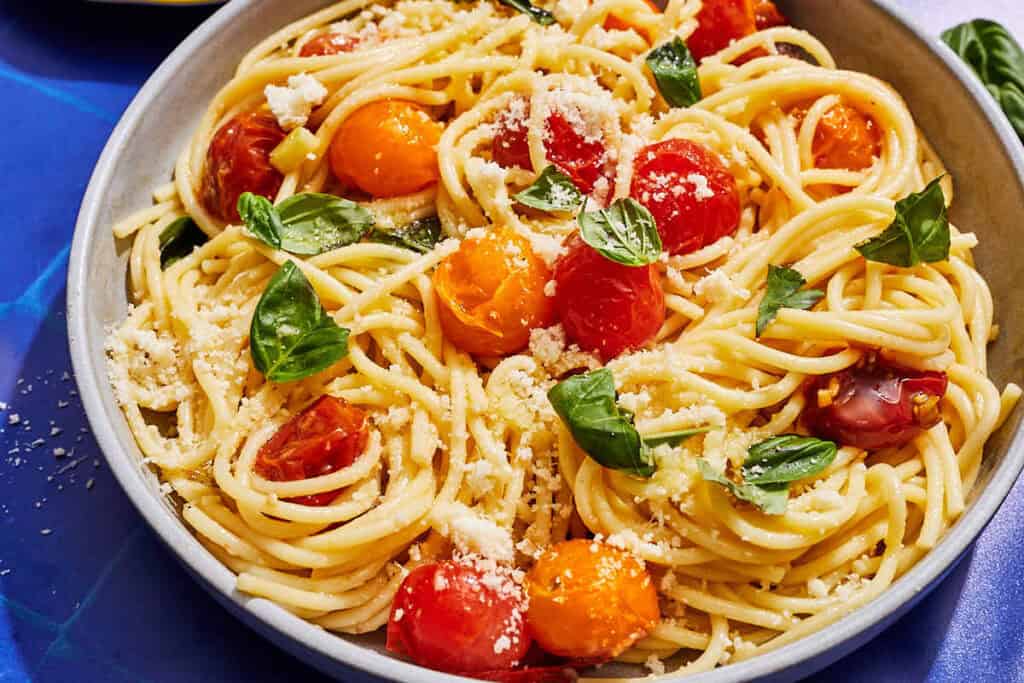 A serving of cherry tomato pasta in a bowl.