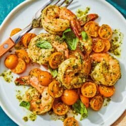 A serving of pesto shrimp on a plate with a fork.
