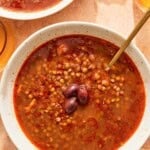Greek lentil soup in a bowl with a spoon.