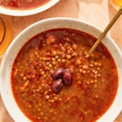 Greek lentil soup in a bowl with a spoon.