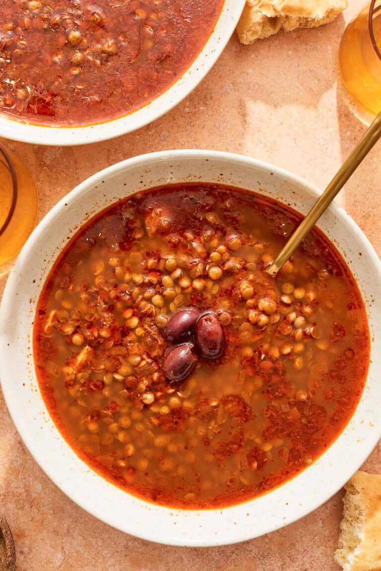 Greek lentil soup in a bowl with a spoon.