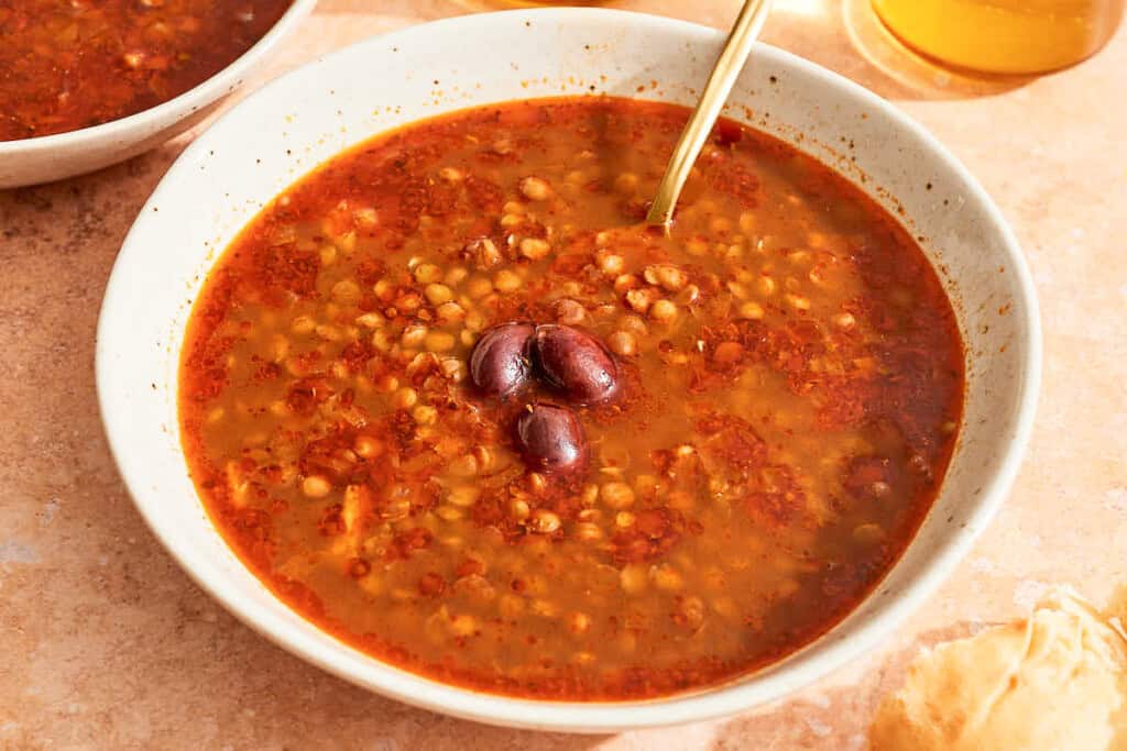 Greek lentil soup in a bowl with a spoon.
