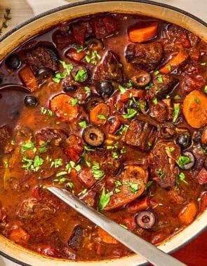 Daube provencal in a large pot with a ladle.