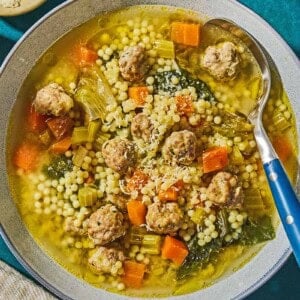 Italian wedding soup in a bowl with a spoon.