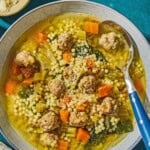 Italian wedding soup in a bowl with a spoon.