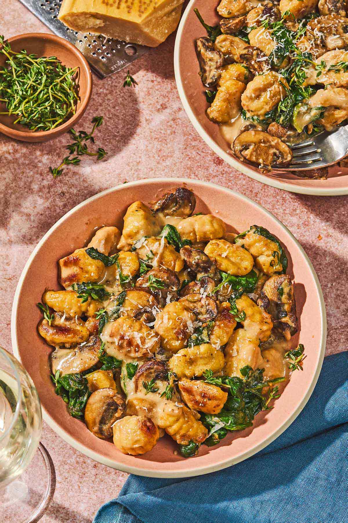 Two bowls of mushroom gnocchi, one with a fork.