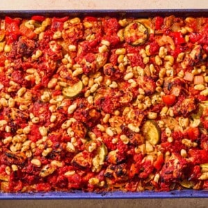 The cooked chicken and vegetables on a sheet pan.