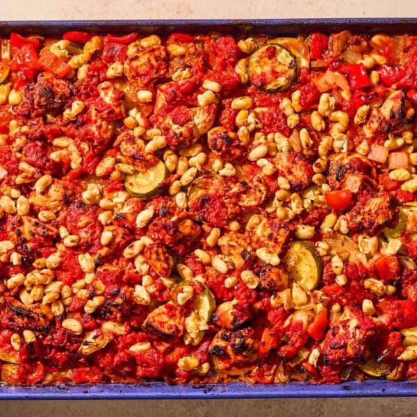 The cooked chicken and vegetables on a sheet pan.
